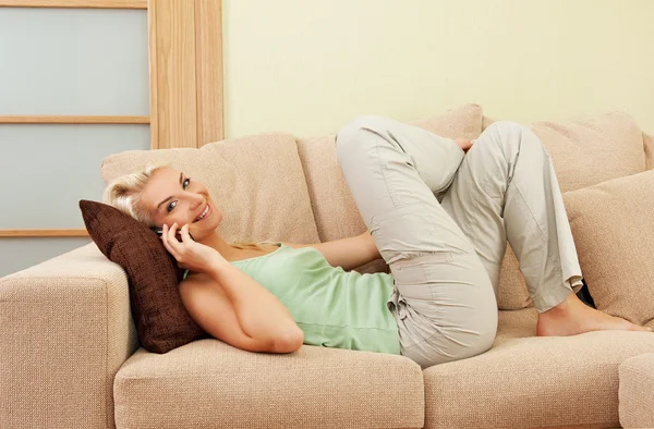 Kobieta, leżąc na kanapie i rozmowy na telefon — Zdjęcie stockowe