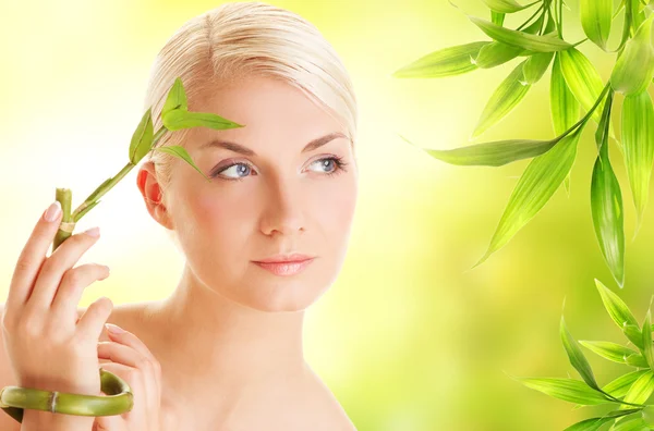 Beautiful young woman with bamboo plant Stock Photo