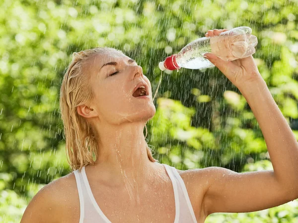 Mulher sexy beber água sob chuva — Fotografia de Stock