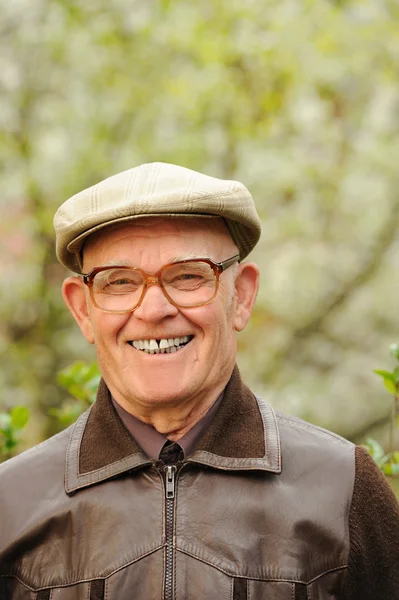 Glad äldre man i trädgården — Stockfoto