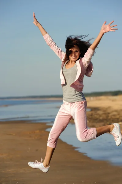 Νεαρή γυναίκα πηδάει στην παραλία — Φωτογραφία Αρχείου