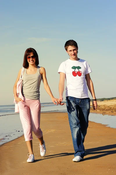 Mladý pár kráčející po pláži — Stock fotografie