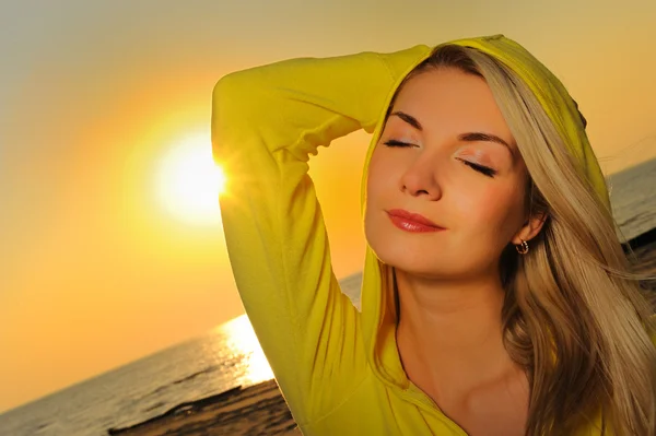 Gyönyörű nő a tengerparton naplementekor — Stock Fotó