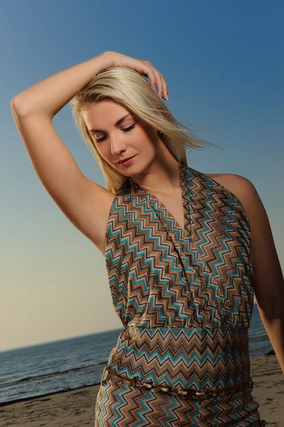 Mulher bonita em uma praia ao pôr do sol — Fotografia de Stock