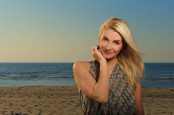 Hermosa mujer en una playa al atardecer — Foto de Stock