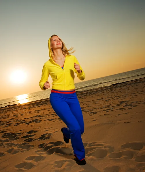 Gyönyörű fiatal nő fut a strandon — Stock Fotó