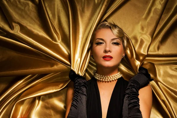 Lovely woman on golden fabric — Stock Photo, Image