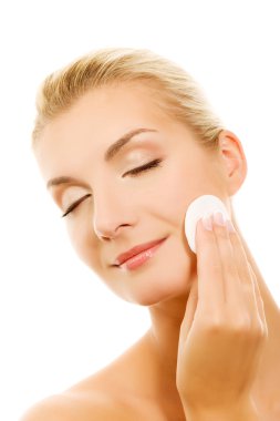 Young woman removing cosmetics clipart