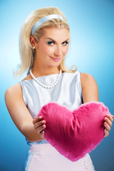Mujer joven con almohada de corazón esponjoso —  Fotos de Stock