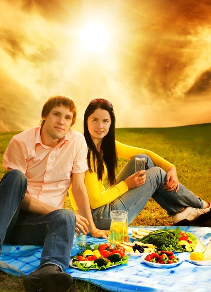 Молодая пара на романтическом пикнике — стоковое фото