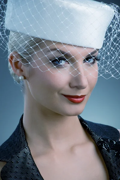 Młoda kobieta w białym kapeluszu z welonem netto — Zdjęcie stockowe