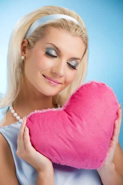Güzel bir kadın ile kabarık kalp yastık — Stok fotoğraf