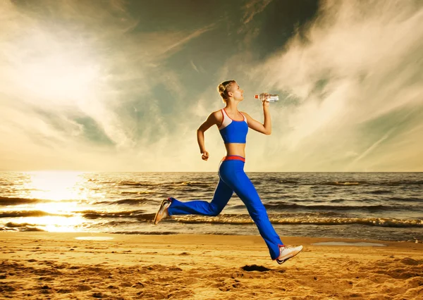 Νεαρή γυναίκα που τρέχει σε μια παραλία — Φωτογραφία Αρχείου