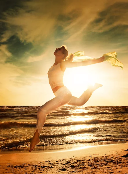 Hermosa mujer saltando en una playa — Foto de Stock
