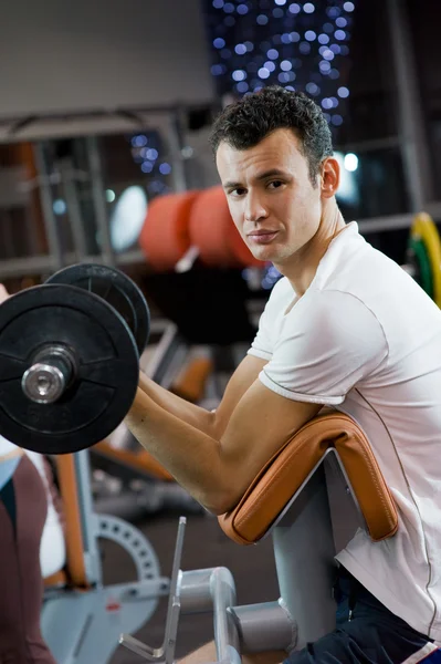 Schöner junger Mann beim Gewichtheben — Stockfoto