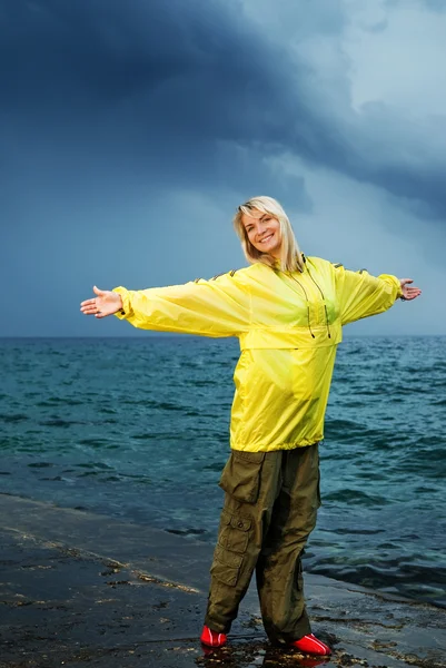 Junge Frau im gelben Regenmantel — Stockfoto