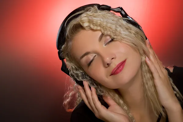 Blonde vrouw luisteren naar de muziek — Stockfoto