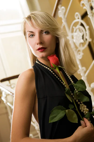Krásná mladá žena s červenou růží — Stock fotografie