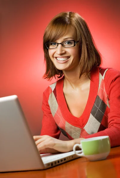 Lachende vrouw die op haar laptop werkt — Stockfoto