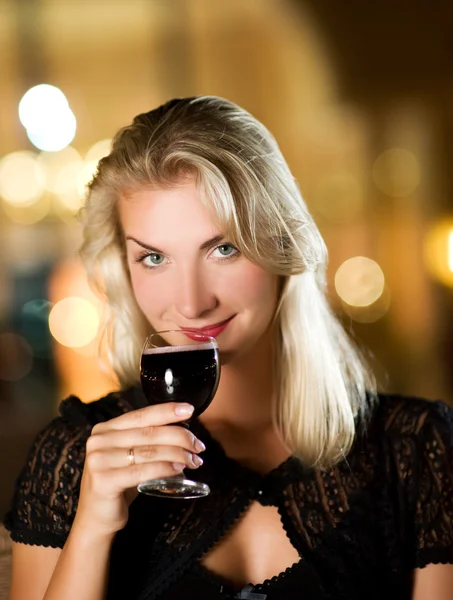 Hermosa joven bebiendo vino tinto — Foto de Stock