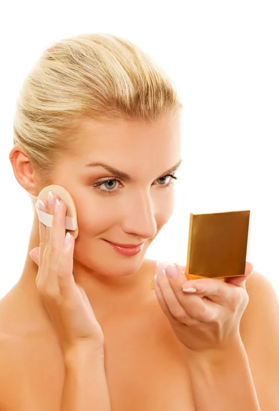 Mujer joven que se aplica maquillaje en la cara — Foto de Stock