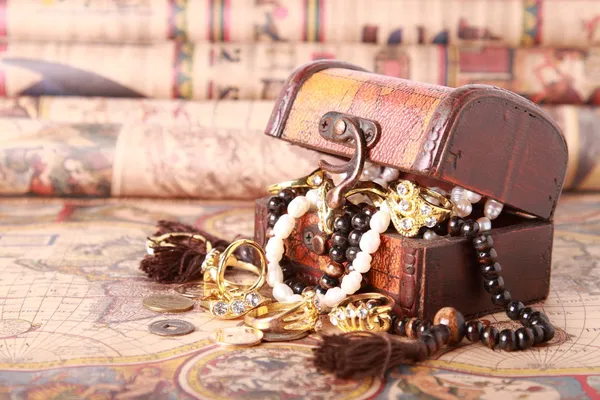 Chest with jewelry on antique map — Stockfoto