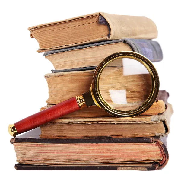 Stack of ancient books and magnifying — Stock Photo, Image