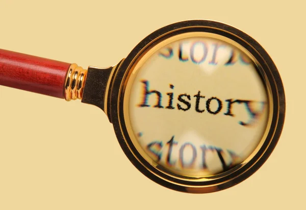 Old magnifying glass on word history — Stock Photo, Image