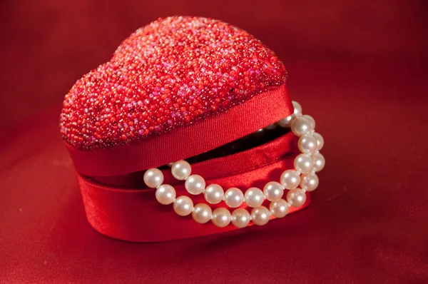 Red heart gift box with string of pearls — Stock Photo, Image