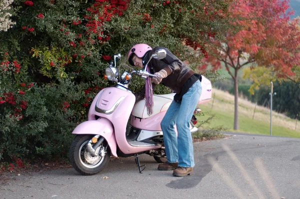 Женщина включает / выключает свой мотоцикл Стоковая Картинка