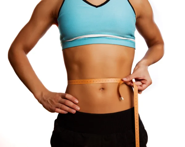 Pretty athlete measures her belly — Stock Photo, Image