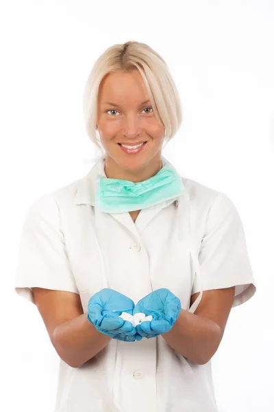 Улыбающаяся медсестра держит таблетки — стоковое фото