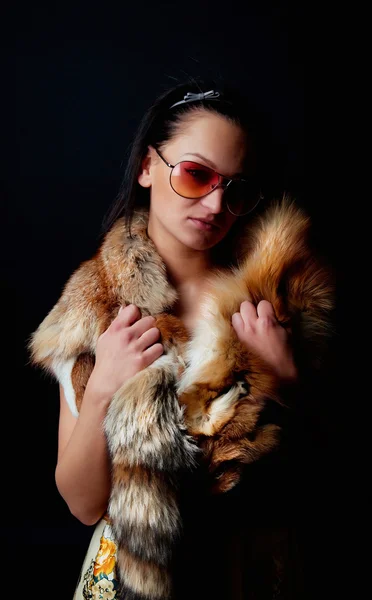 Bruna seducente con pelliccia in mano — Foto Stock