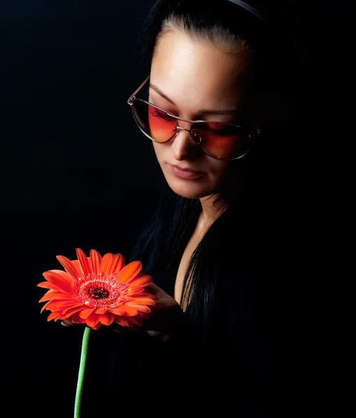 Femme mignonne tenant une fleur rouge — Photo