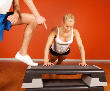 Trainer and trainee in fitness room clipart