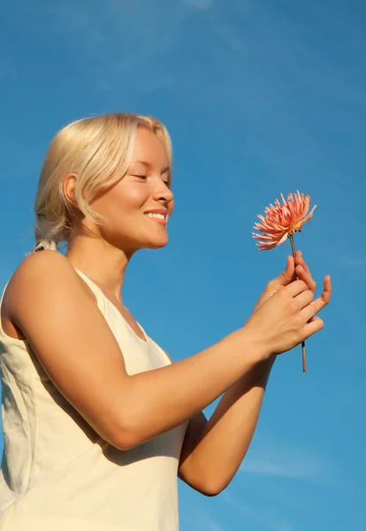 Portret uśmiechający się blondynka z kwiatem — Zdjęcie stockowe