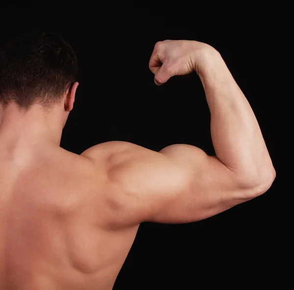 Спортсмен показывает свои мускулы — стоковое фото
