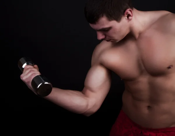 Hombre guapo sosteniendo pesas — Foto de Stock