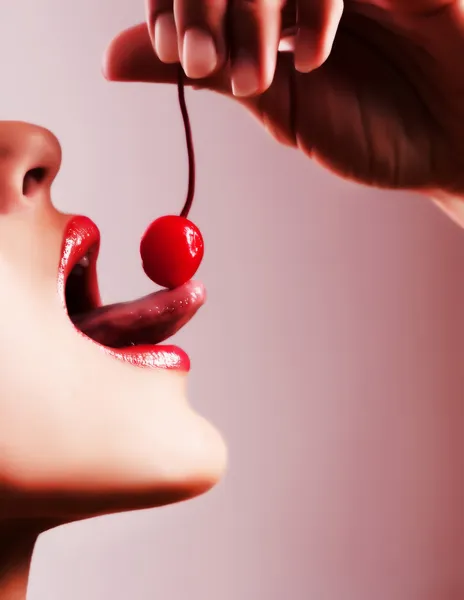 Woman tasting a cherry — Stock Photo, Image
