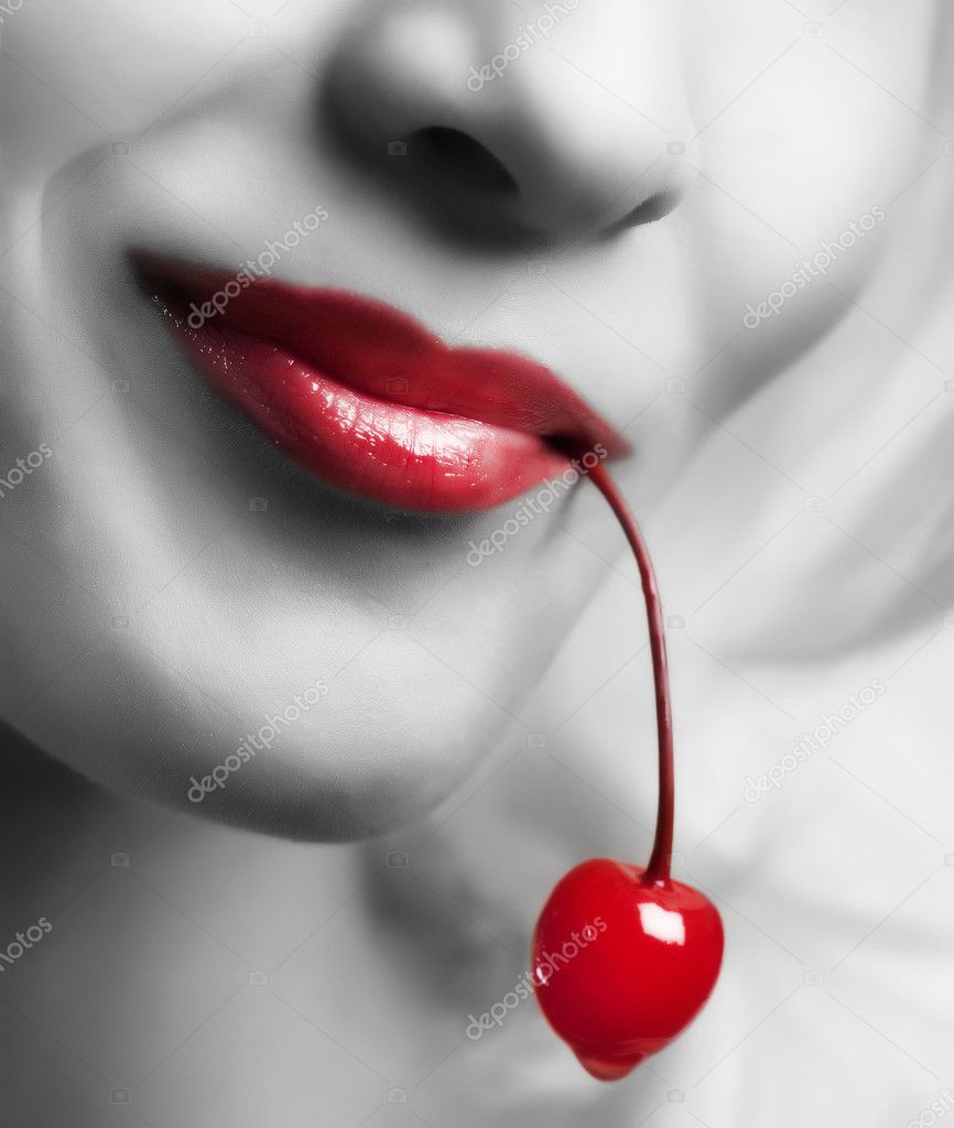 Sexy lips holding a cherry