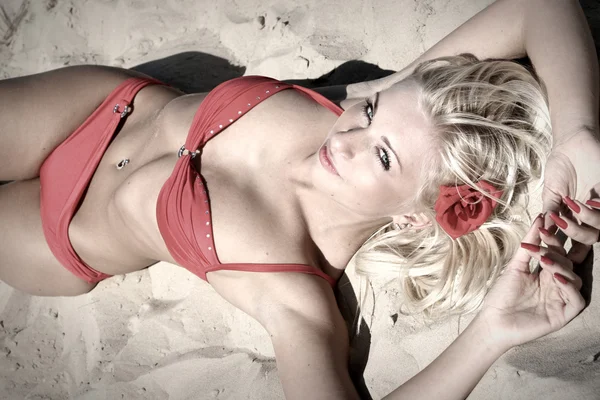 Jonge vrouw in rode bikini op het strand — Stockfoto