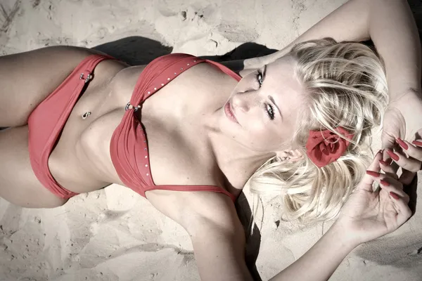 Junge Frau im roten Bikini am Strand Stockbild