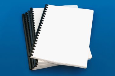 Spiral bound book, over blue background clipart