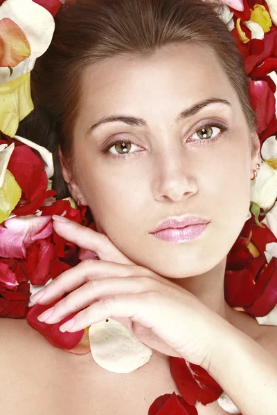 Vacker flicka med röda rosor kronblad — Stockfoto