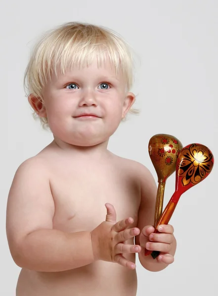 Baby boy plays with wood spoon — Stock Photo, Image