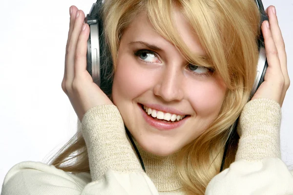 Kvinnan lyssnar musik i hörlurar — Stockfoto