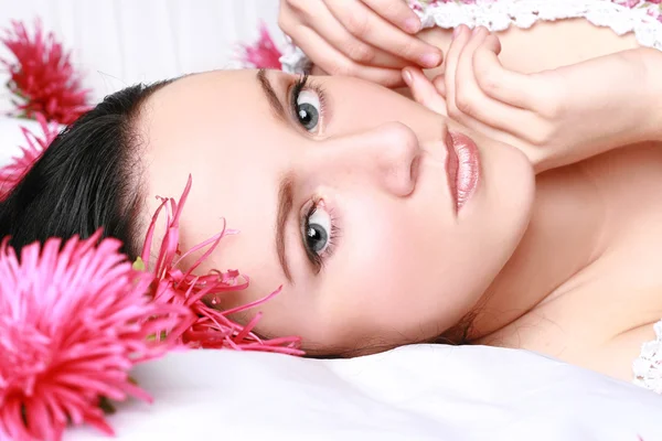 Brunette met roze bloem — Stockfoto