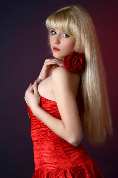 Молодая красивая женщина с красной розой — стоковое фото