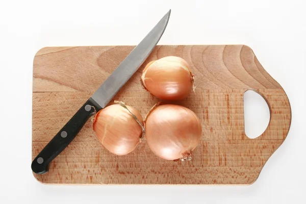 Onions on a chopping board. — Stock Photo, Image