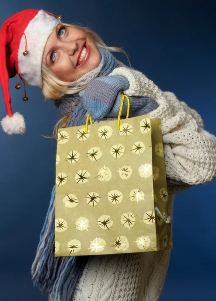 Hediye çanta ile Noel Baba şapkalı sarışın kız — Stok fotoğraf